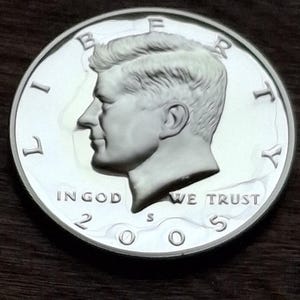 K&ouml;nnte beinhalten: Eine silberne 2005 Kennedy Half-Dollar-M&uuml;nze. Die M&uuml;nze zeigt ein Profil von John F. Kennedy und die Inschriften "LIBERTY", "IN GOD WE TRUST" und "UNITED STATES OF AMERICA".