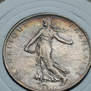 Puede incluir: Moneda francesa de plata con la inscripción "REPUBLIQUE FRANCAISE" y la representación de una mujer sosteniendo una rama.