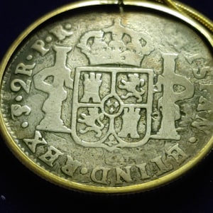 Op de afbeelding: Zilveren munthanger met een goudkleurig frame en ketting. De munt heeft een gedetailleerd wapen en tekst. De hanger is een vintage stuk, waarschijnlijk een verzamelobject of historisch item.