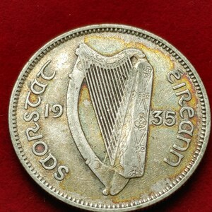 May include: Silver Irish coin with a harp design and the text "Saorstát Éireann 1935" around the edge.