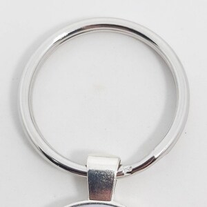 May include: Silver key ring with a round metal loop. The loop is smooth and shiny.