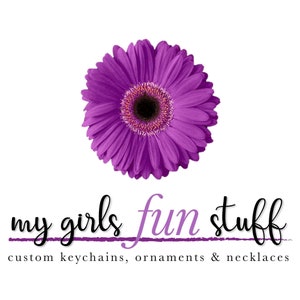 May include: Purple daisy flower with a black center. Text reads "my girls fun stuff custom keychains, ornaments & necklaces".