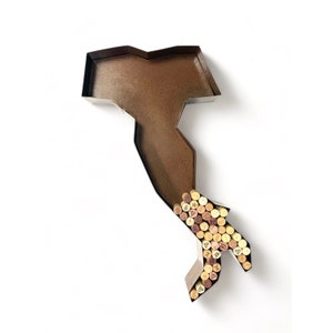 May include: A metal outline of the Italian peninsula filled with wine corks. The outline is a dark brown color and the corks are a variety of natural colors.