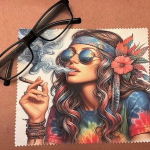 May include: A colorful microfiber cleaning cloth with a tie-dye pattern and a drawing of a woman with long hair wearing a headband and sunglasses, smoking a cigarette.