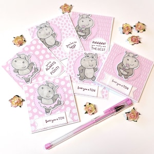 May include: Five pink and white greeting cards with a hippopotamus illustration on each. The cards have different messages, including "You're so hip", "You're always on point!" and "Awhhh! You really are the best".