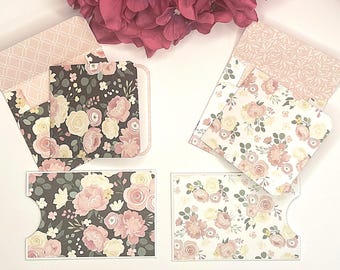 May include: Floral-patterned stationery set featuring envelopes and cards. The cards and envelopes display a mix of floral designs in pink, cream, and green on a dark gray and white background. The envelopes have a light pink patterned interior.
