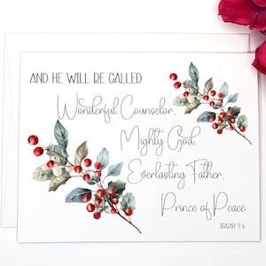 May include: A white card with a Christmas-themed design featuring red berries and green leaves. The card has a quote from Isaiah 9:6, "And he will be called Wonderful Counselor, Mighty God, Everlasting Father, Prince of Peace."