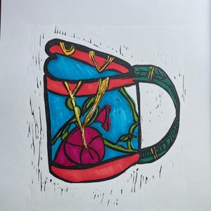 Könnte beinhalten: Handgezeichnete Illustration einer farbenfrohen Tasse. Die Tasse hat ein blaues Inneres mit einer rosa Blume und grünen Ranken. Der Rand und der Henkel sind rot und grün, mit goldenen Akzenten. Das Kunstwerk ist vor einem weißen Hintergrund.