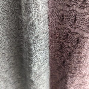 K&ouml;nnte beinhalten: Nahaufnahme eines weichen, gestrickten Stoffes mit einem zarten Spitzenmuster. Der Stoff ist links hellgrau und rechts dunkelgrau.