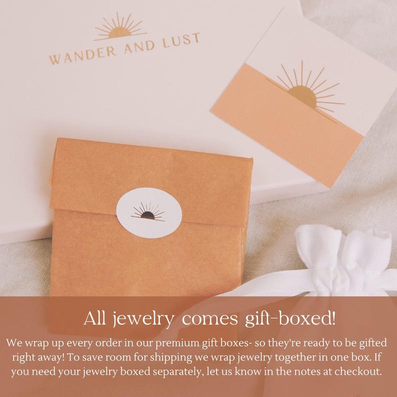 Puede incluir: Primer plano de un embalaje de joyas con el texto "WANDER AND LUST". La imagen muestra un peque&ntilde;o paquete de papel marr&oacute;n doblado con una pegatina blanca y un dise&ntilde;o de sol. Tambi&eacute;n se ven una caja de regalo y una tarjeta.