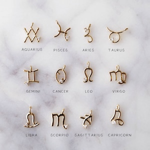 May include: Twelve gold zodiac sign charms with a small diamond accent. The charms are arranged in three rows of four. The signs are Aquarius, Pisces, Aries, Taurus, Gemini, Cancer, Leo, Virgo, Libra, Scorpio, Sagittarius, and Capricorn.