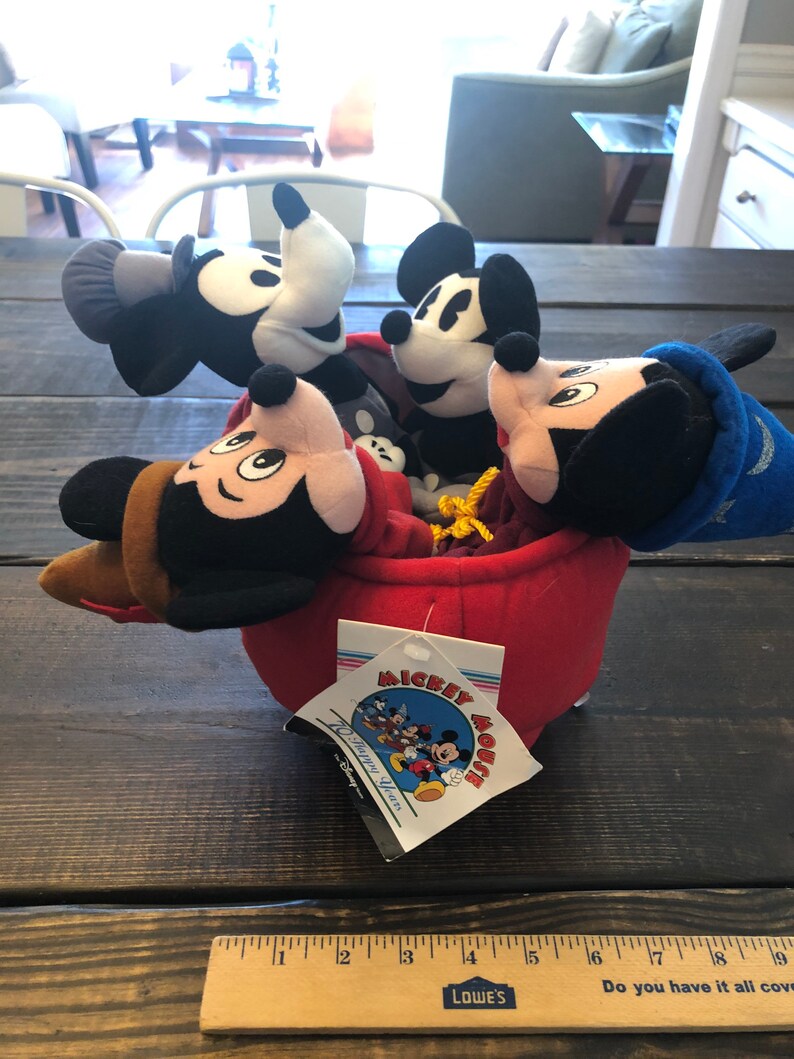 Peut inclure: Une maison en peluche rouge Mickey Mouse avec quatre figurines en peluche Mickey Mouse &agrave; l'int&eacute;rieur. La maison a une &eacute;tiquette qui dit "Mickey Mouse 70 Happy Years".