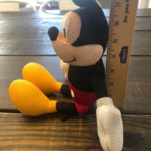 May include: A black and red plush Mickey Mouse toy with yellow mesh ears and hands. The toy is 7 inches tall and is sitting on a wooden surface. "Do you have it at"