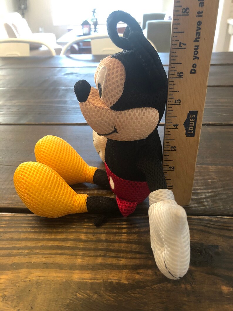 May include: A black and red plush Mickey Mouse toy with yellow mesh ears and hands. The toy is 7 inches tall and is sitting on a wooden surface. "Do you have it at"