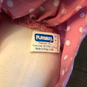 May include: A white tag with blue lettering that reads "PLAYSKOOL Playskool, Inc., Pawtucket, RI 02862 U.S.A Made In China. C-281" and "REG. NO. PA-3307 (RC)" with a number "28" printed on the tag.