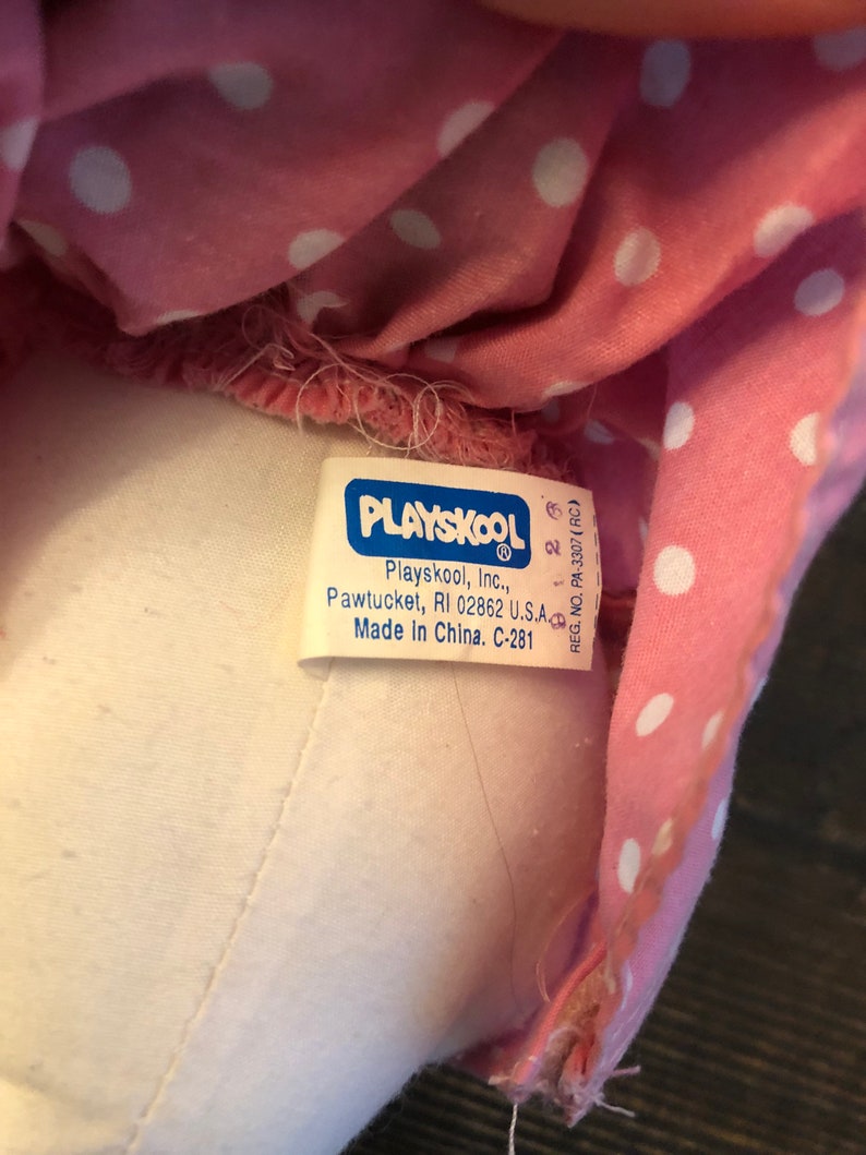 May include: A white tag with blue lettering that reads "PLAYSKOOL Playskool, Inc., Pawtucket, RI 02862 U.S.A Made In China. C-281" and "REG. NO. PA-3307 (RC)" with a number "28" printed on the tag.