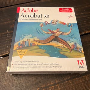 May include: A box for Adobe Acrobat 5.0 software for Windows. The box features a cartoon illustration of a person juggling a globe, a document, and a letter 'A'. The text on the box reads "Adobe Acrobat 5.0" and "The best way to share documents online".