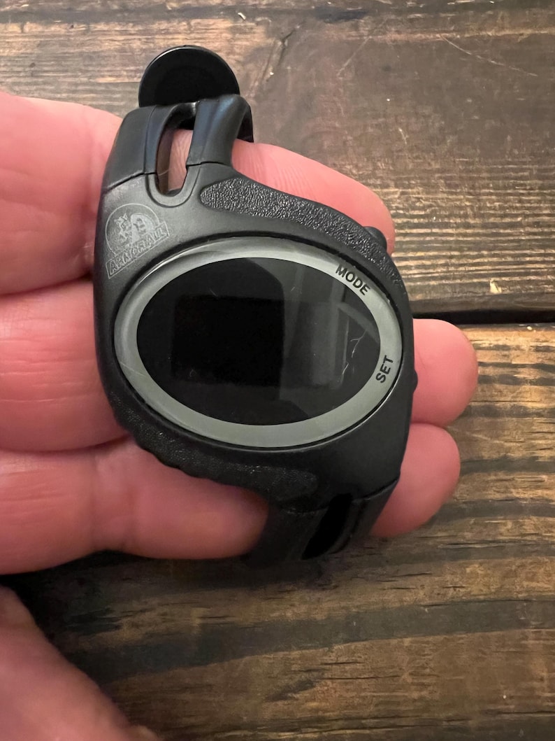 May include: Black digital watch with the text "MODE" and "SET". The watch has a black strap and a digital display. The brand name "ARMORALL" is visible on the watch face.