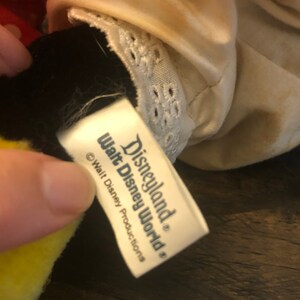May include: White tag with black text that reads "Disneyland&reg; Walt Disney World&reg;" and "&copy; Walt Disney Productions".