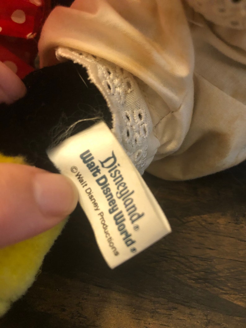 May include: White tag with black text that reads "Disneyland&reg; Walt Disney World&reg;" and "&copy; Walt Disney Productions".