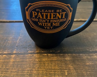 Please be patient God isn’t finished with me yet Black and Orange Coffee Mug