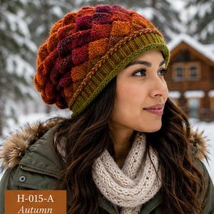 May include: A knit beanie featuring a textured, scale-like pattern in gradient shades of orange, red, and burgundy, finished with a ribbed olive green brim. The beanie displays the text H-015-A Autumn in the lower left corner of the image.