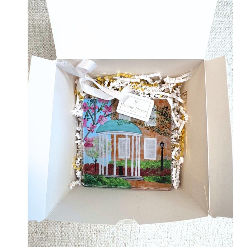 Decorative UNC Chapel Hill acrylic ornament with satin ribbon ideal for holiday decorating and college gift giving.
UNC Tar Heels Old Well ornament created from original Jeanne Player artwork for alumni gifts and Christmas decor.