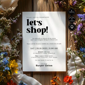 Może przedstawiać: Biała karta zaproszenia z napisem "let's shop!" pogrubioną, czarną czcionką. Karta otoczona jest kolorowymi kwiatami i zielenią na drewnianej powierzchni. Zaproszenie zawiera szczegóły dotyczące brunchu i wydarzenia ślubnego.