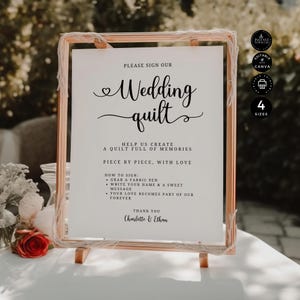 May include: A framed sign with the text "Wedding quilt" in elegant script. The sign includes instructions for guests to sign a quilt, with the names "Charlotte & Ethan" at the bottom. The frame is a light brown color.