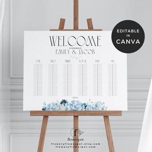 May include: A white wedding seating chart on a wooden easel. The chart features the words "WELCOME" and "EMILY & JACOB" in elegant black font. It includes a list of names and is decorated with blue floral accents. The words "EDITABLE IN CANVA" are in a black circle.