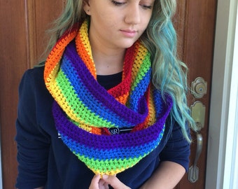 May include: A rainbow colored crocheted infinity scarf. The scarf is made with a variety of colors, including red, orange, yellow, green, blue, indigo, and violet.