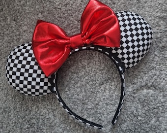 May include: Checkered black and white mouse ears headband with a large red bow.