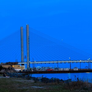 Kuststrandprint. Charles W Cullen Bridge Indian River Inlet bij zonsondergang. Bootpaden, rode verlichting, reflecties op de baai. Digitaal beeld
