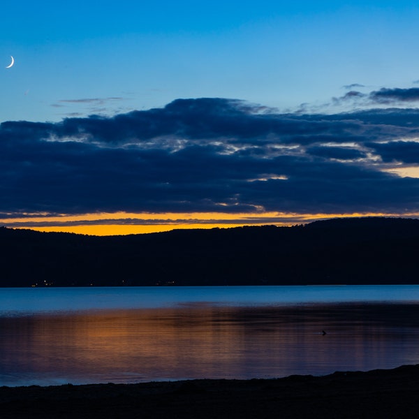 Sunset at Otsego Lake, Glimmerglass State Park, NY. Blue and orange sky. Reflection on the lake. Digital Image