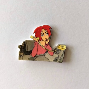 May include: A cartoon woman with red hair and a pink shirt is on the phone, sitting at a desk with a yellow phone.