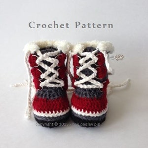 May include: A pair of red, white, and gray crocheted baby booties with white laces. The booties have a boot shape with a fold-over cuff. The text "copyright © 2015 - one paisley pig" is visible below the booties.