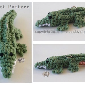 Puede incluir: Llavero de cocodrilo verde tejido a crochet con un anillo plateado. El cocodrilo sostiene un pequeño amuleto plateado en su boca. Copyright 2015 - one paisley pig.