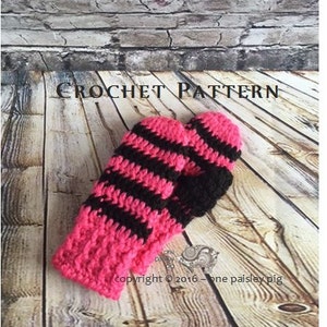 May include: A pair of crochet mittens featuring horizontal stripes in alternating hot pink and black yarn. The text CROCHET PATTERN is visible at the top, and the text copyright 2016 one paisley pig is visible near the bottom of the mittens.
