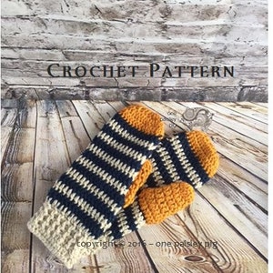 May include: A pair of crochet mittens featuring a striped pattern in navy blue, cream, and mustard yellow. The mittens have a solid mustard yellow thumb and rounded tip, with a cream-colored cuff. The text CROCHET PATTERN is visible.
