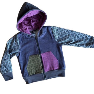 May include: A navy blue zip-up hoodie with geometric patterned sleeves and a color-blocked pocket. The hood lining is a deep purple with a geometric design. The hoodie has a full zipper and a ribbed hem and cuffs.