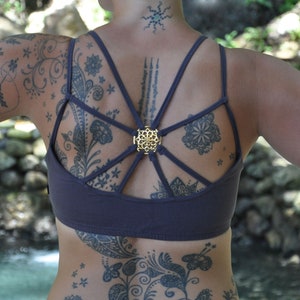 yoga top with detailed back design and brass elements in grey