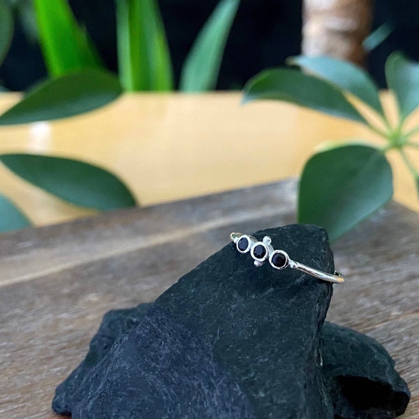 filigraner Ring mit Kügelchen und drei kleinen schwarzen facettierten Steinen aus Silber