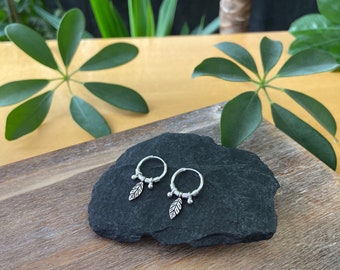 small silver hoop earrings with little leaf