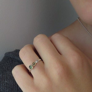 silver ring with brass spiral and green stone