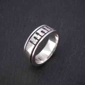 Anillo giratorio para hombre de plata con árboles estampados.