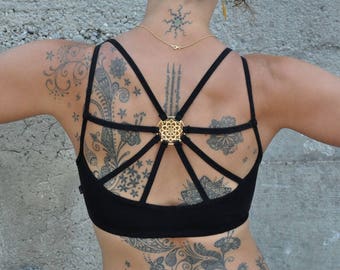 yoga top with detailed back design and brass elements in black