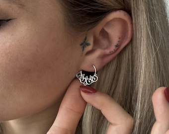 May include: A silver hoop earring featuring a decorative semi-circular attachment with intricate swirling filigree patterns and small spherical bead accents along the bottom edge, designed to hang from the lower portion of the earlobe.