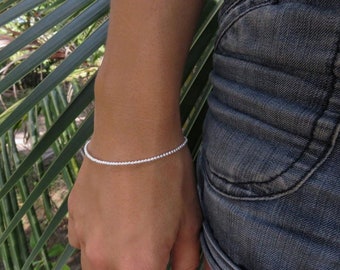 pulseira simples feita de pequenas bolas de prata com mosquetão