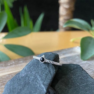 silver ring with small stone and little ball