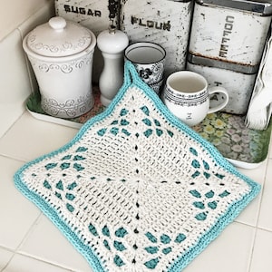 May include: Handmade white and teal crochet potholder with a square shape and decorative openwork design. The potholder has a teal border and a loop for hanging. Kitchen decor.